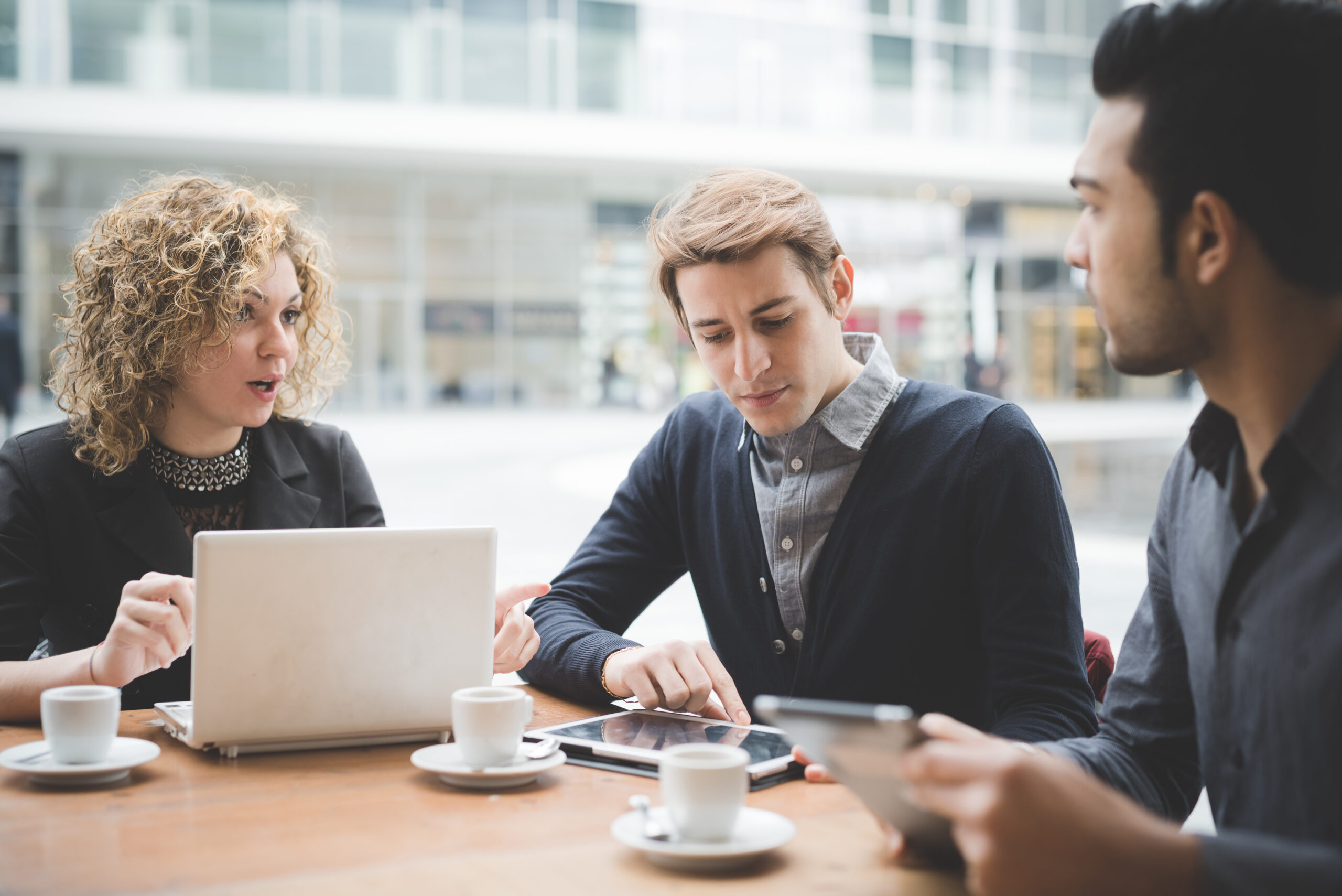Multiracial business people working connected with technological devices at the bar